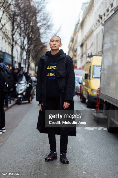 Model Zhang Wenhui wears all black - a parka, Balenciaga hoodie pants, and Nike Air Max sneakers during Paris Fashion Week Menswear Fall/Winter 2018...