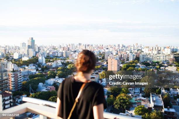 rear view of woman standing at building terrace against cityscape - buenos-aires imagens e fotografias de stock