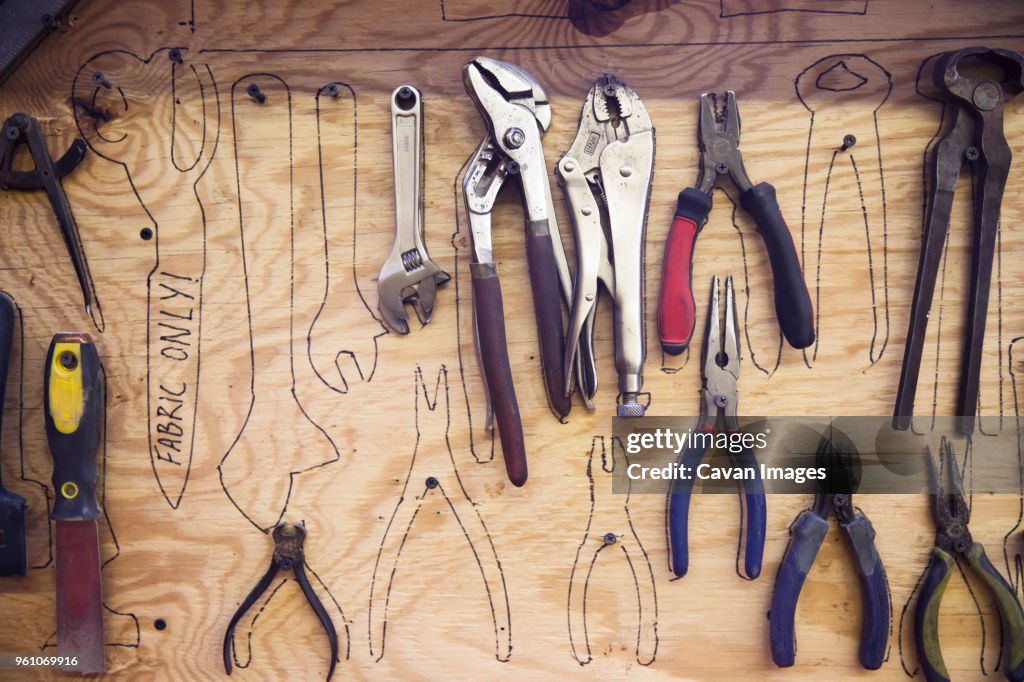 Tools hanging over sketches made on wooden wall