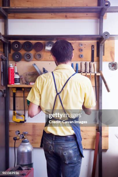 rear view of manual worker standing at workshop - tool rack stock pictures, royalty-free photos & images