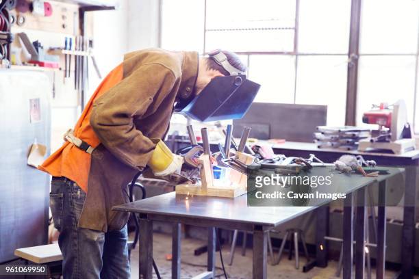 male craftsperson welding metal at wood shop - tool rack stock pictures, royalty-free photos & images