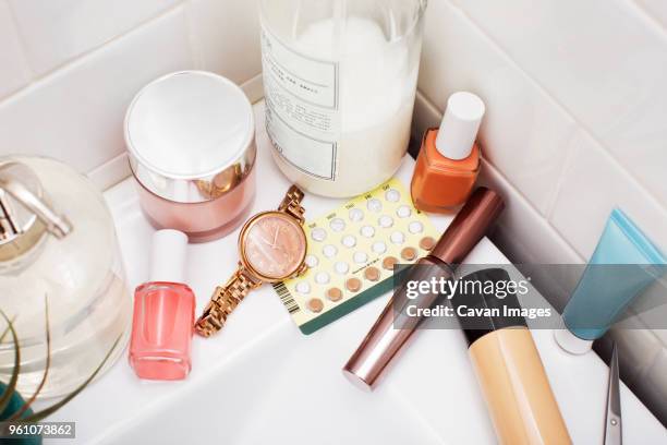 overhead view of beauty products on bathroom sink - bathroom sink stock-fotos und bilder