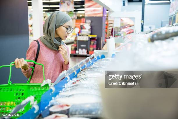 vrouwen alleen winkelen bij boodschappen - viswinkel stockfoto's en -beelden