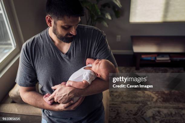 high angle view father carrying son while standing at home - father holding sleeping baby stockfoto's en -beelden