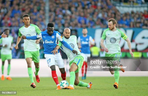 Felix Uduokhai , John Anthony Brooks and Maximilian Arnold of VfL Wolfsburg fights for the ball with Kingsley Schindler of Holstein Kiel during the...