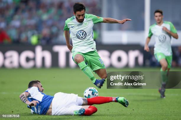 Yunus Malli of Wolfsburg outjumps Dominik Schmidt of Kiel during the Bundesliga Playoff Leg 2 match between Holstein Kiel and VfL Wolfsburg at...