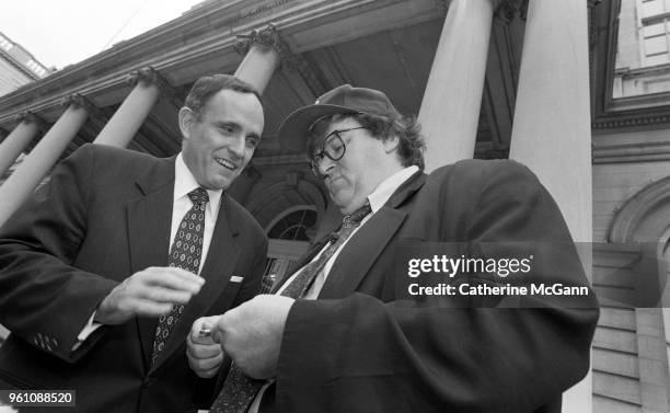 American filmmaker Michael Moore, right, and New York City Mayor Rudolph Giuliani outside City Hall, during taping of an episode of Moore's NBC...