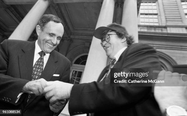 American filmmaker Michael Moore, right, and New York City Mayor Rudolph Giuliani outside City Hall, during taping of an episode of Moore's NBC...