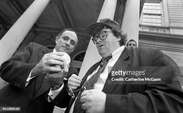 American filmmaker Michael Moore, right, and New York City Mayor Rudolph Giuliani outside City Hall, during taping of an episode of Moore's NBC...