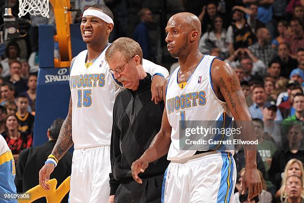 Carmelo Anthony is helped off by Head athletic trainer Jim Gillen and Chauncey Billups of the Denver Nuggets against the New Orleans Hornets on...