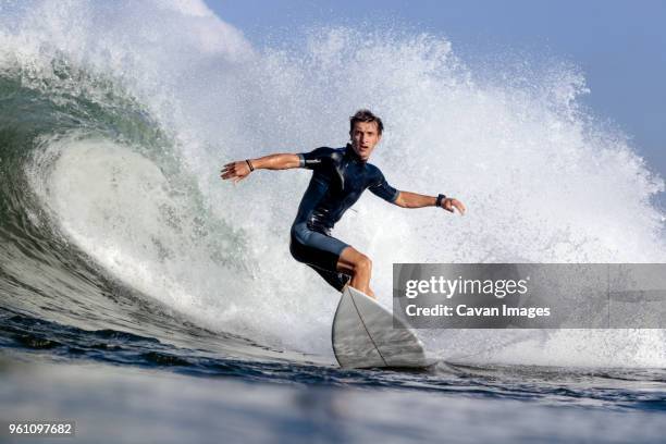 low angle view of man surfing on sea - surfer wetsuit stockfoto's en -beelden