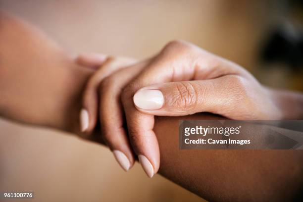 cropped image of woman touching hand - fingernail stock pictures, royalty-free photos & images
