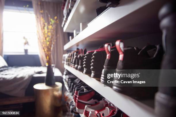 close-up of shoes arranged in shelf at home - shoe collection stockfoto's en -beelden