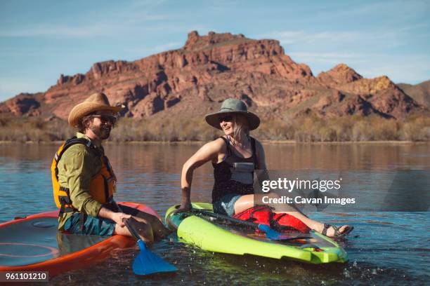 happy couple sitting on paddleboards at lake - phoenix arizona stock pictures, royalty-free photos & images