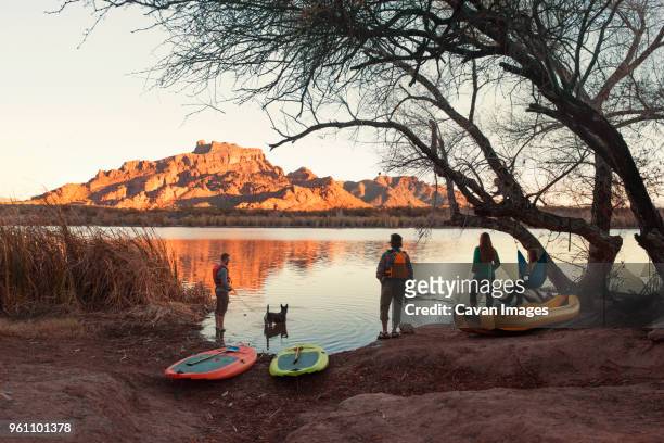 friends with water sport equipment at lakeshore during dusk - phoenix arizona stock-fotos und bilder