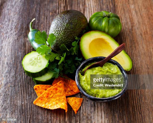 bowl of guacamole, ingredients and tortilla chips - slätpersilja bildbanksfoton och bilder