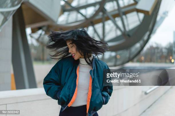 france, paris, smiling young woman tossing her hair - fashionable asian stock pictures, royalty-free photos & images