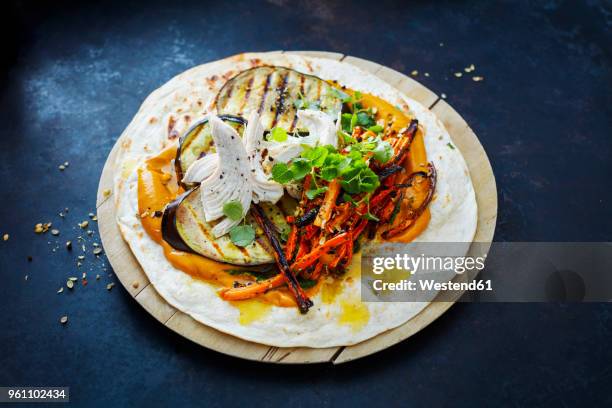 pulled chicken wrap, carrot, grilled aubergine, curry hummus and herbs on chopping board - pulled chicken stock pictures, royalty-free photos & images