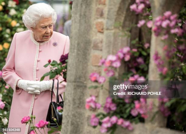 Britain's Queen Elizabeth II looks at a display of roses on the Peter Beale stand as she visits the 2018 Chelsea Flower Show in London on May 21,...