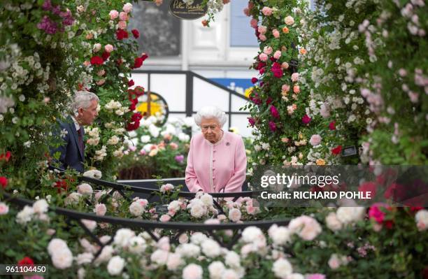 Britain's Queen Elizabeth II looks at a display of roses on the Peter Beale stand as she visits the 2018 Chelsea Flower Show in London on May 21,...