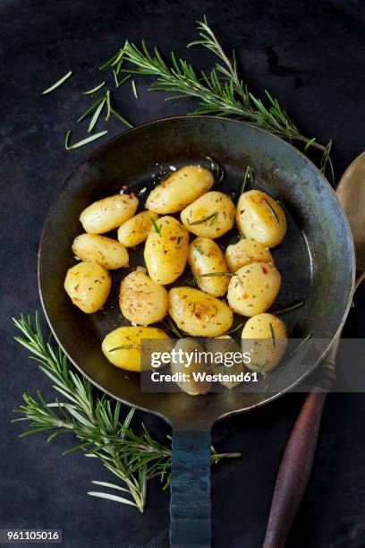fried potatoes with rosmary in pan - gekookte aardappel stockfoto's en -beelden