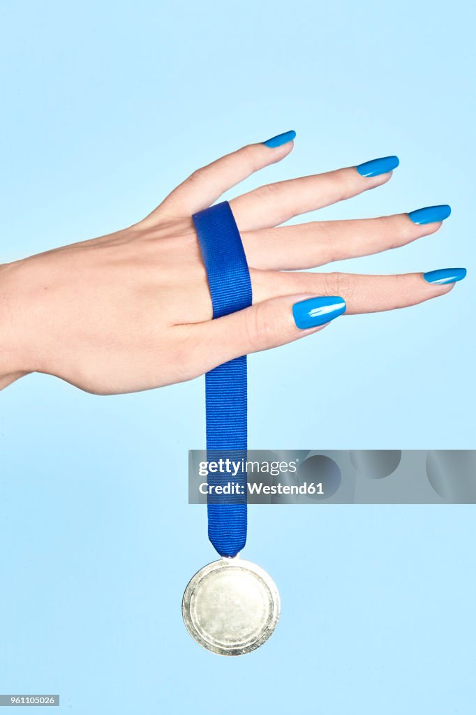 Close-up of woman's hand holding a medal