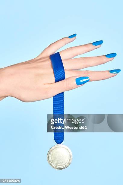 close-up of woman's hand holding a medal - medalist foto e immagini stock