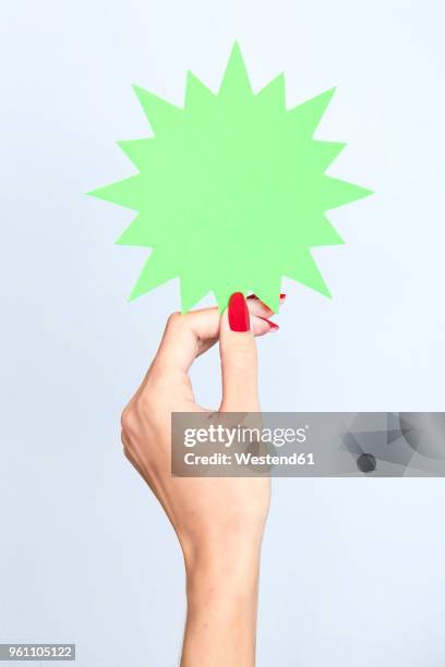 close-up of woman's hand holding a blank jagged sign - レッドマニキュア ストックフォトと画像
