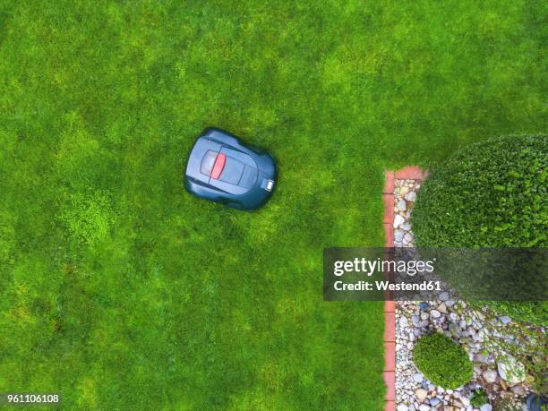 germany, bavaria, robotic lawn mower on meadow - lawnmower stock-fotos und bilder
