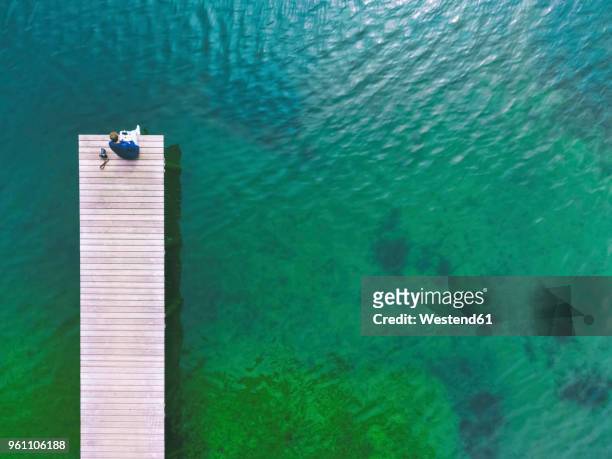 germany, bavaria, chiemsee, man sitting on jetty - jetty lake stock pictures, royalty-free photos & images
