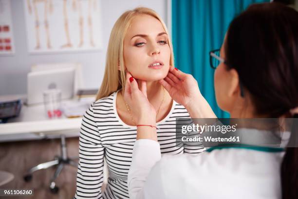 doctor examining young woman in medical practice - sore throat stock pictures, royalty-free photos & images