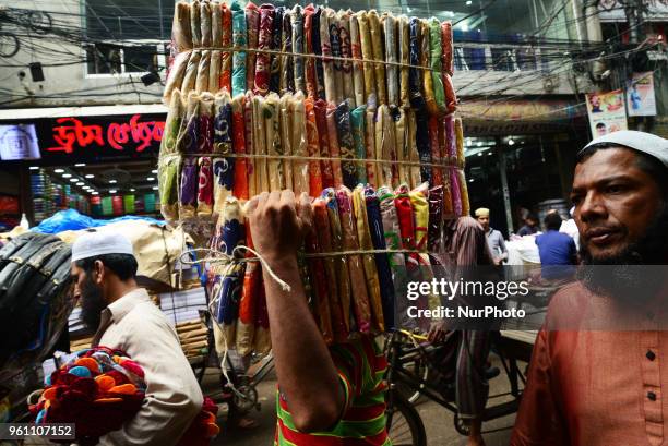 Bangladeshi Day Labor carries clothe in the whole sell clothes market in Dhaka, Bangladesh on May 21, 2018.