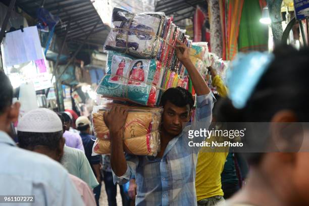 Bangladeshi Day Labor carries clothe in the whole sell clothes market in Dhaka, Bangladesh on May 21, 2018.