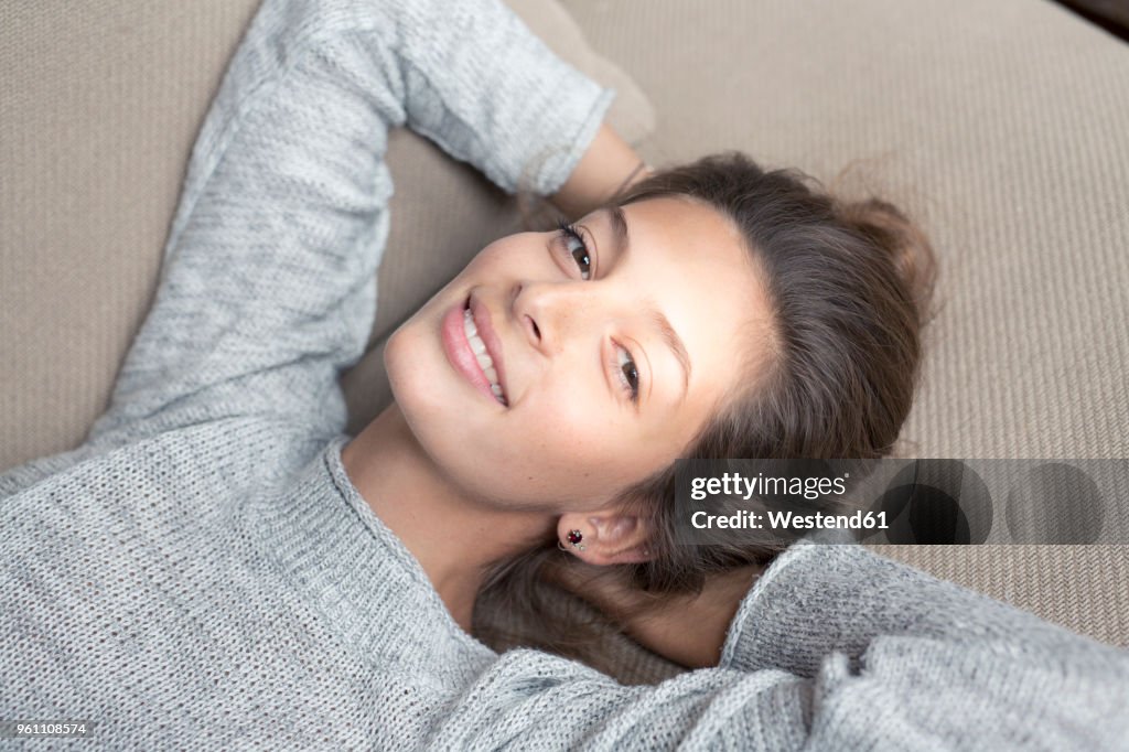 Portrait of smiling woman lying on couch