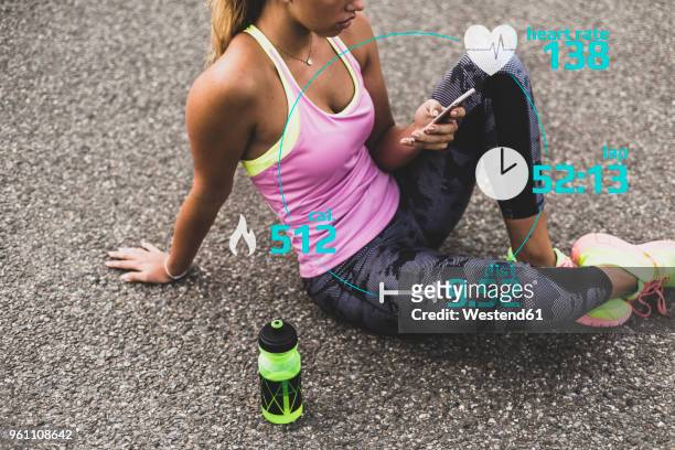 sportive young woman having a break with data emerging from smartphone - duration of training stock pictures, royalty-free photos & images