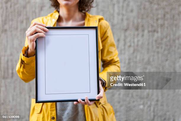 close-up of woman holding blank frame - blank frame stockfoto's en -beelden