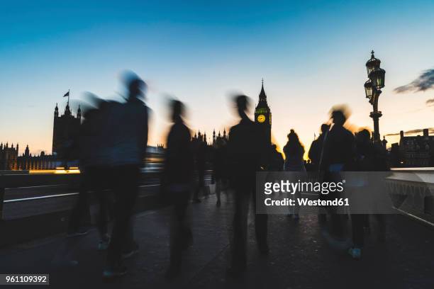 uk, london, silhouette of people on westminster bridge with big ben in background at sunset - person falls from westminster bridge stock-fotos und bilder