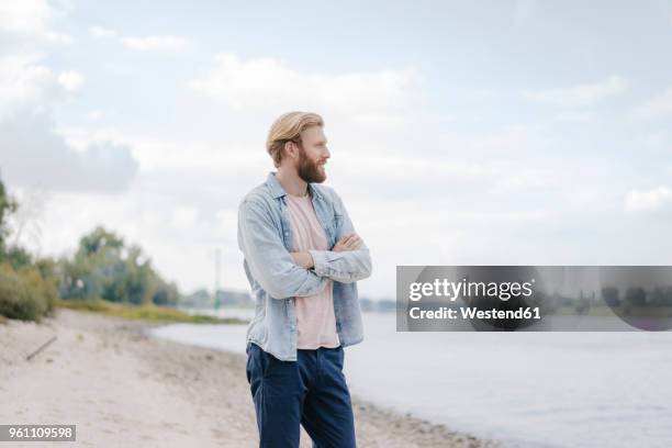 germany, duesseldorf, man standing at riverside looking at view - north rhine westphalia photos et images de collection