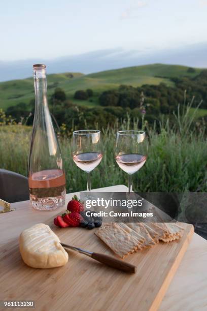 food and wine on wooden plank outside suv against rolling landscape - wine bottle transport stock pictures, royalty-free photos & images