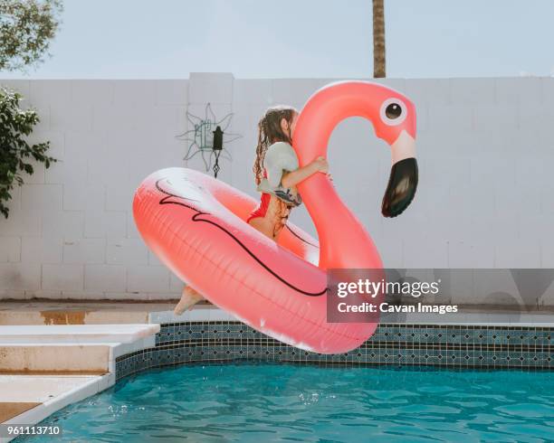 girl jumping with rubber duck in swimming pool - inflatable pool toys imagens e fotografias de stock