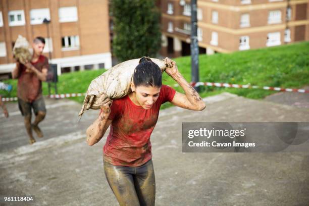 high angle view of participants carrying sandbag and climbing steps during race - sandbag stock pictures, royalty-free photos & images