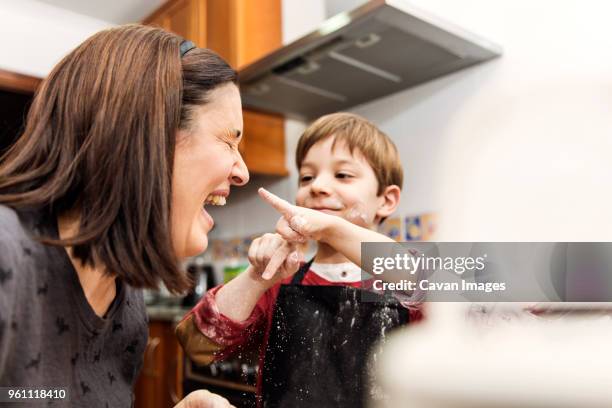mother and son laughing while cooking together - cooking mess imagens e fotografias de stock