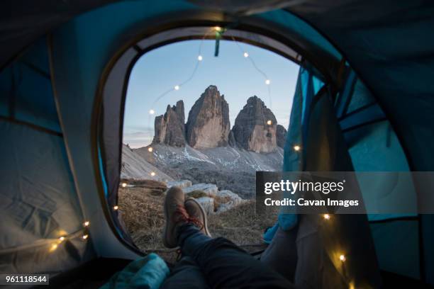 low section of man sitting in tent on mountain during sunset - personal perspective view stock pictures, royalty-free photos & images