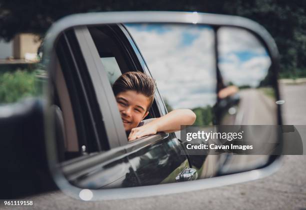reflection of cheerful boy seen in side-view mirror at car - side view mirror stock pictures, royalty-free photos & images