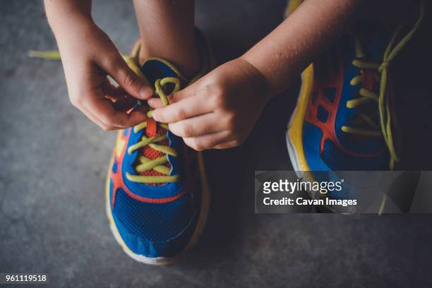 cropped hands of boy tying shoelace - tied up stock pictures, royalty-free photos & images