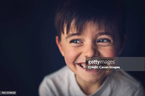 cheerful boy with gap toothed looking away in darkroom - losing virginity - fotografias e filmes do acervo