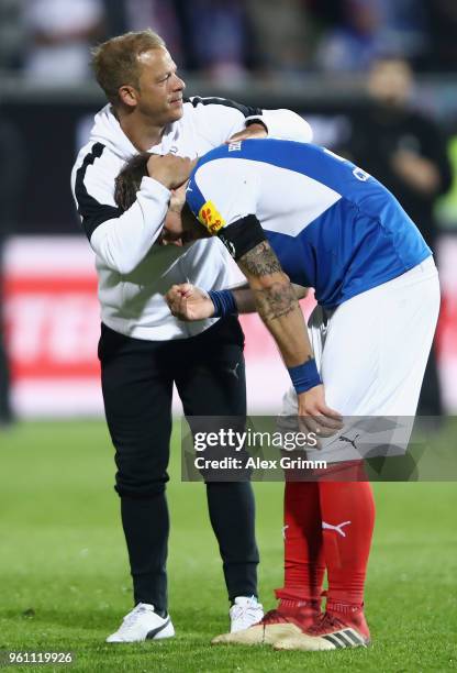 Head coach Markus Anfang of Kiel consoles team captain Rafael Czichos after the Bundesliga Playoff Leg 2 match between Holstein Kiel and VfL...