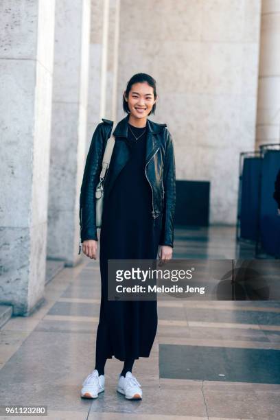 Japanese model Chiharu Okunugi wears a black leather jacket and long dress and white sneakers after the Redemption show at Palais de Tokyo on October...