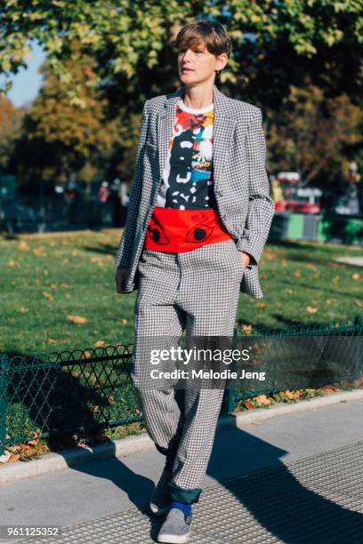 Stella Tennant attends the Chanel show at Grand Palais in a black and white blazer and pants, a Comme des Garcons play printed t-shirt, and gray...