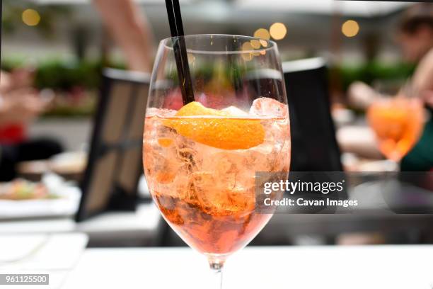 close-up of cocktail in wineglass with drinking straw on table at restaurant - frozen drink stock pictures, royalty-free photos & images